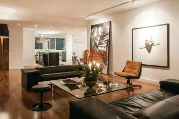 Na sala de TV, sofás Brigardier, mesa de centro de vidro, banco Saarinen e cadeira de couro comprada em antiquário. O quadro de coração é de Hildebrando de Castro