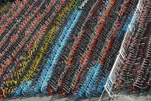 Milhares de bicicletas em desuso, empilhadas em um estacionamento na China