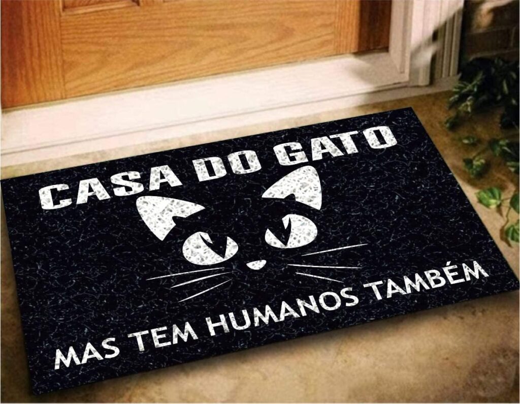 Capacho preto com escrita em branco dizendo "casa do gato mas tem humanos também".