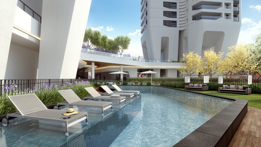 Área das piscinas com deck molhado, ao lado de torres residenciais com design sofisticado de luxo.