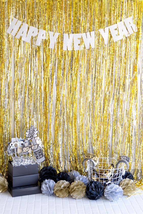 Decoração com cortina metalizada dourada e prata e outros diversos elementos. Cria o clima de final de ano para suas festas.