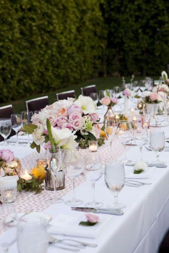 Mesa de jantar completa, decorada com lindas flores e velas.