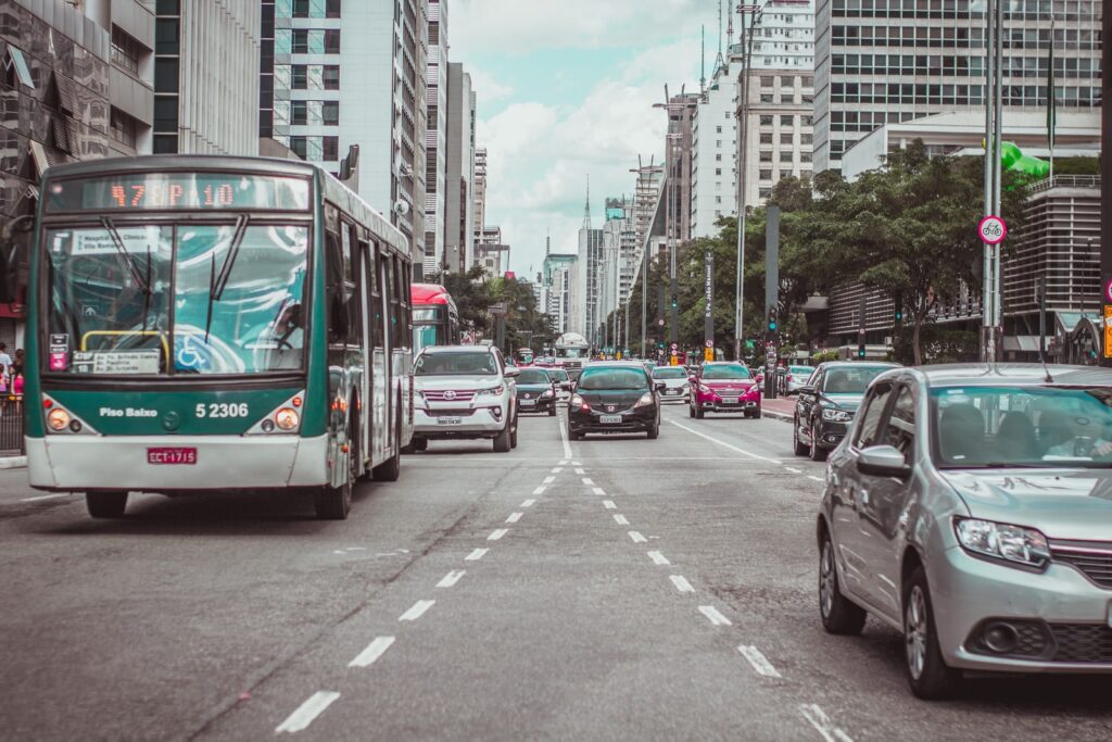 Trânsito da cidade de São Paulo com carros e ônibus.