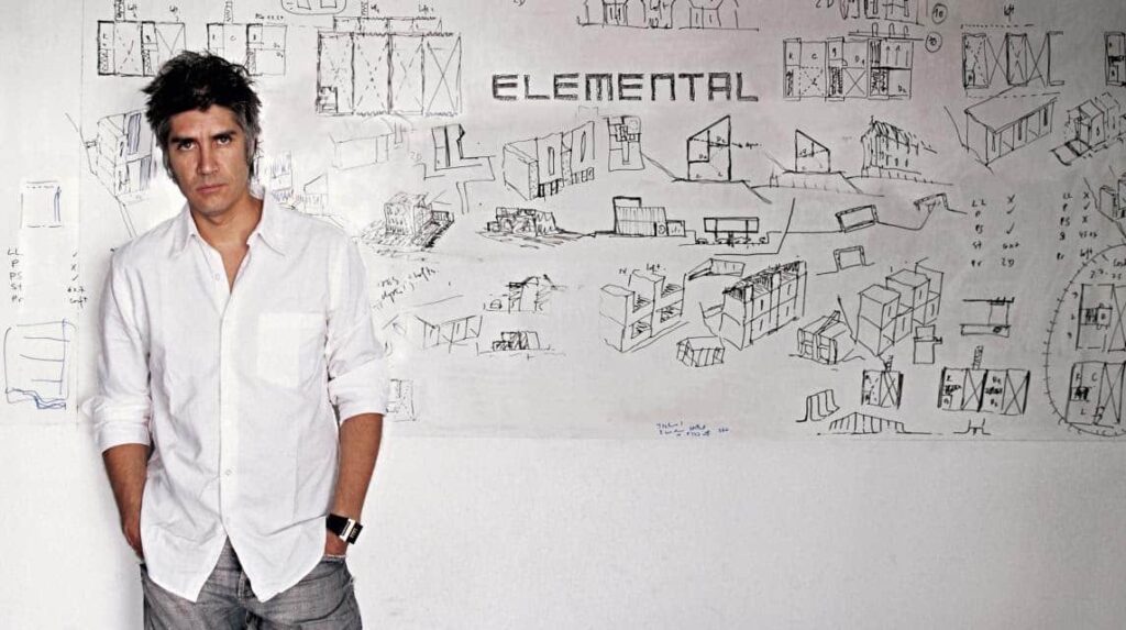 Alejandro Aravena posa em frente a uma ilustração do escritório Elemental S.A. 