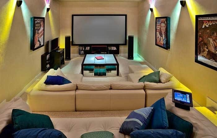 Sala de cinema em casa com tela compatível ao tamanho do espaço proposto para o cômodo.