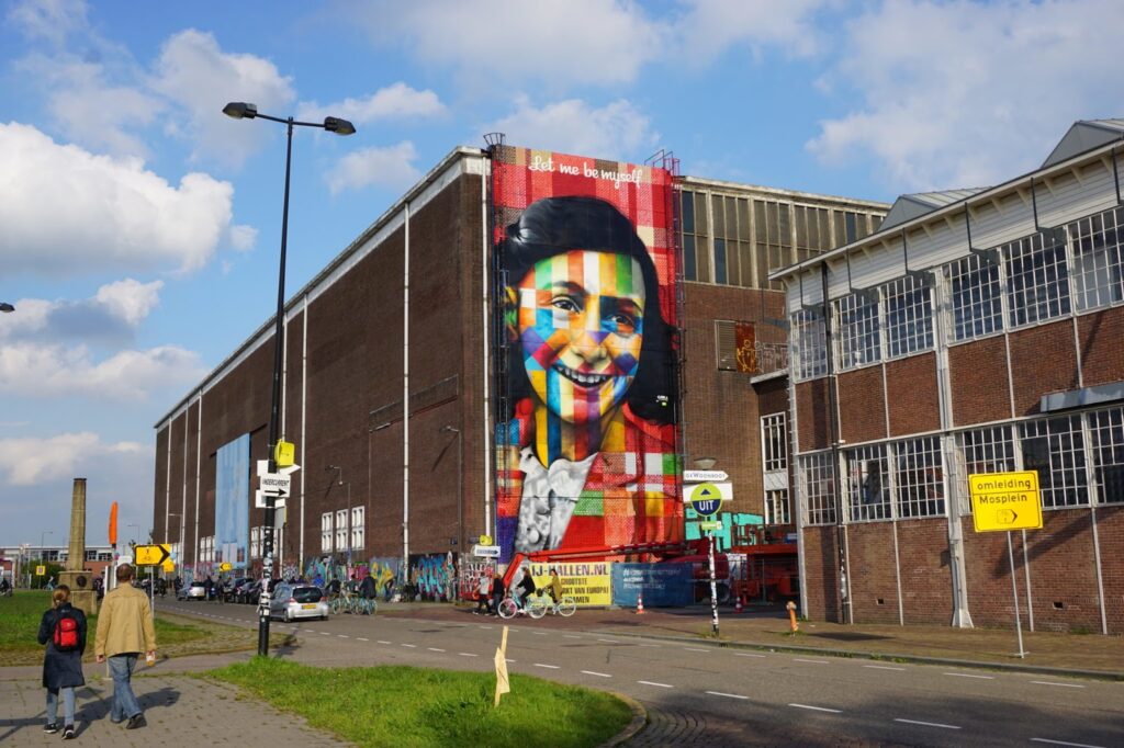 Representando a resistência, a obra contém uma foto da menina Anne Frank sorrindo. A cor vermelha se destaque na trama colorida que também possui cores como verde, amarelo, azul, roxo, branco e preto. A frase "let me be myself" está bem no topo da pintura, em branco.