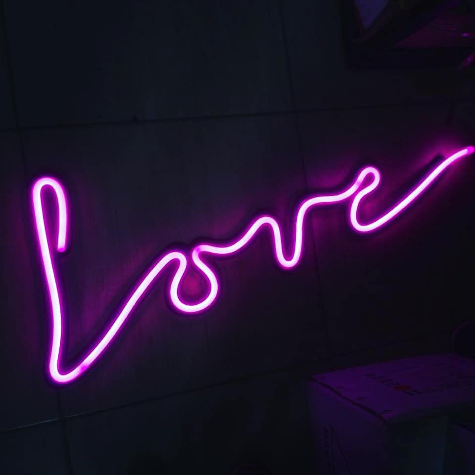 Letreiro feito com luzes neon, com a palavra love (amor, em português).