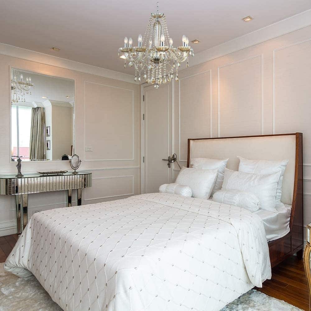 Lustre brilhante em uma quarto com decoração mais clássica.