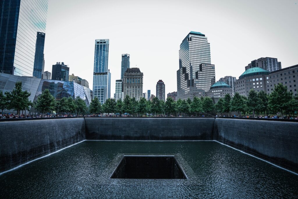 O Memorial World Trade Center se parece com uma cratera, preenchida por uma linha d'água. No entorno, os edifícios altos contrastam com um dos mais conhecidos monumentos históricos.