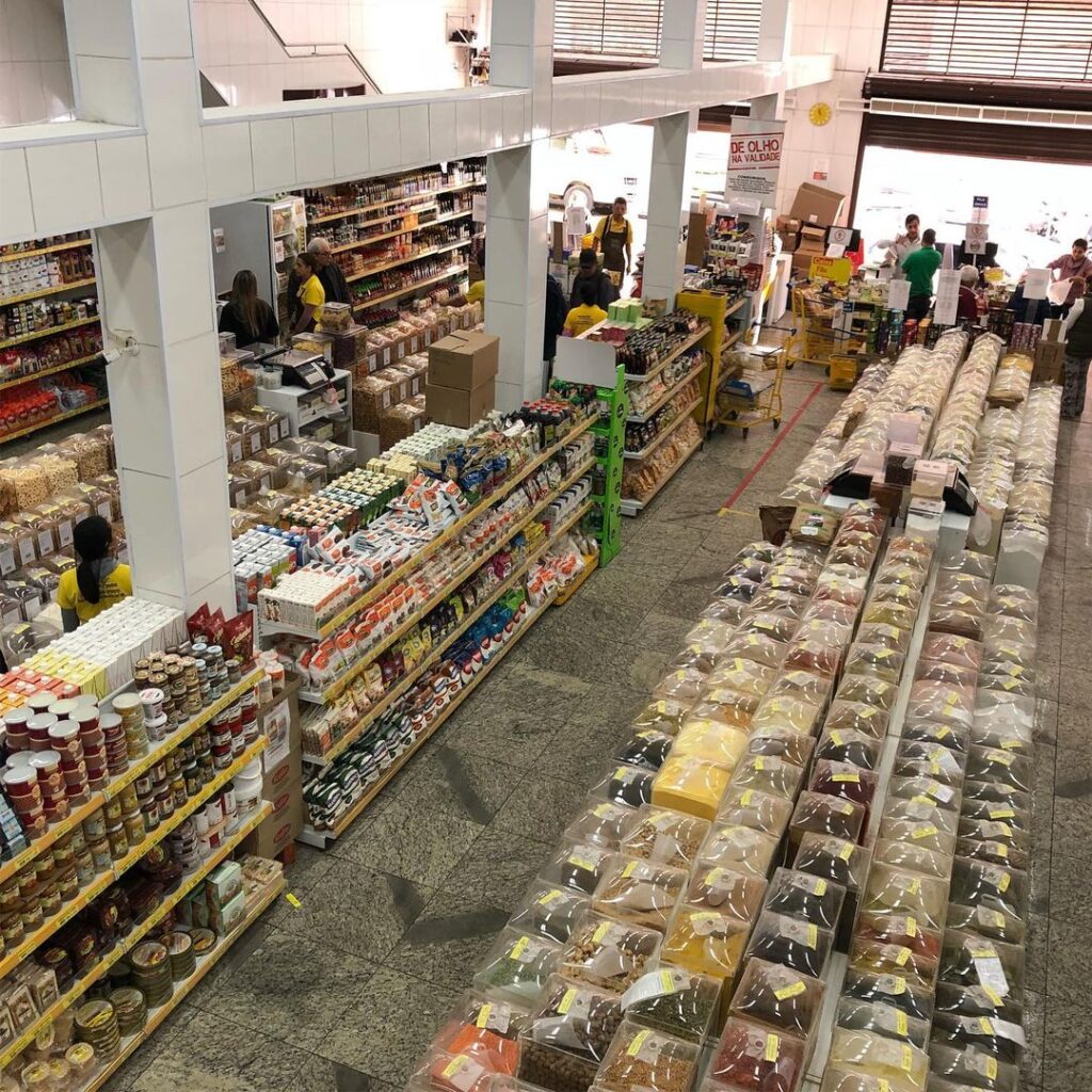 Típico interior de uma loja de produtos da Zona Cerealista. Conta com expositores de produto a granel e prateleiras com produtos embalados.