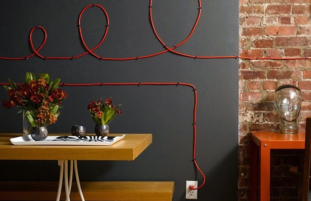 O cabo vermelho foi usado na parede chumbo, dando cor e um toque lÃºdico ao ambiente, por meio de formas espirais.