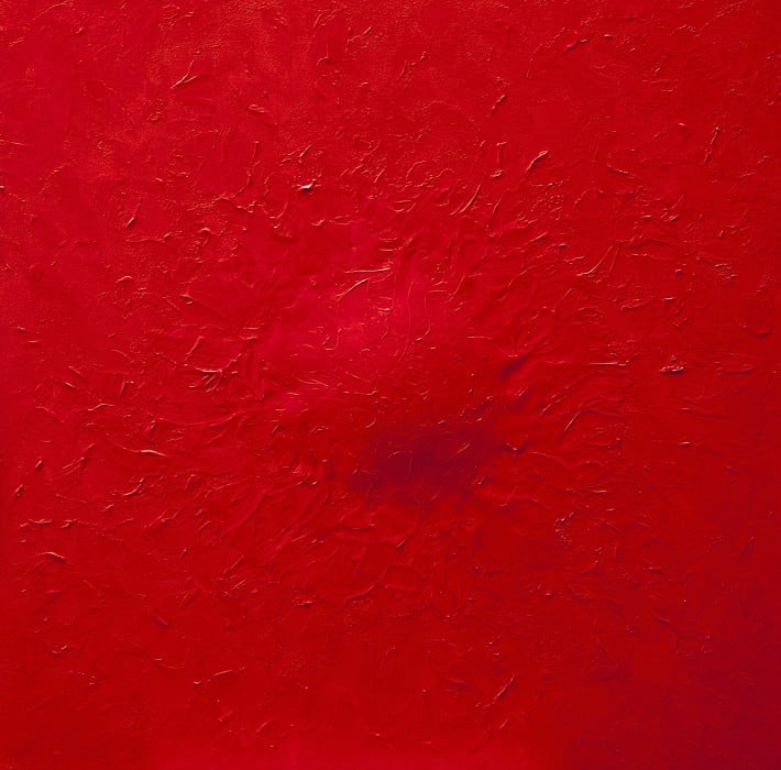 Pintura com diversas camadas sobrepostas formando um relevo circular ao centro. O Vermelho vivo está sempre presente nas obras de Tomie Ohtake.