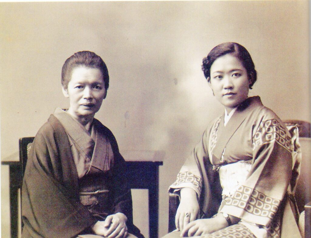 Tomie Ohtake jovem ao lado de sua mãe, ambas em trajes tipicamente orientais.