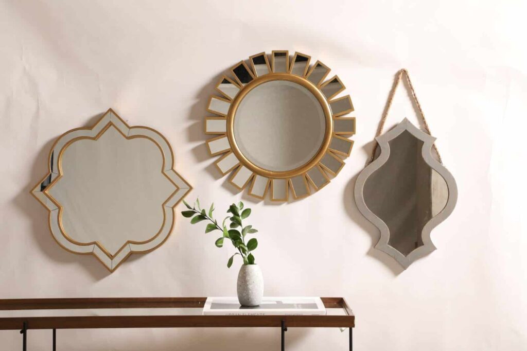 Três espelhos em diferentes formatos contribuindo com a decoração do espaço e amplitude visual do ambiente.
