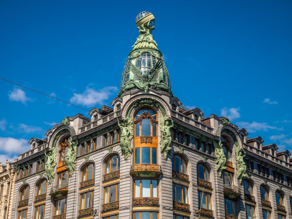 Edifício Art Nouveau, com janelas e cúpula coroadas por esculturas com muito movimento.
