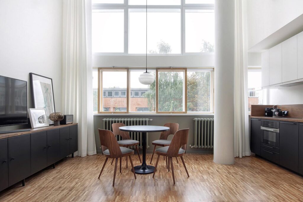 Interior de apartamento duplex com pé-direito ampliado que proporciona maior entrada de iluminação natural.