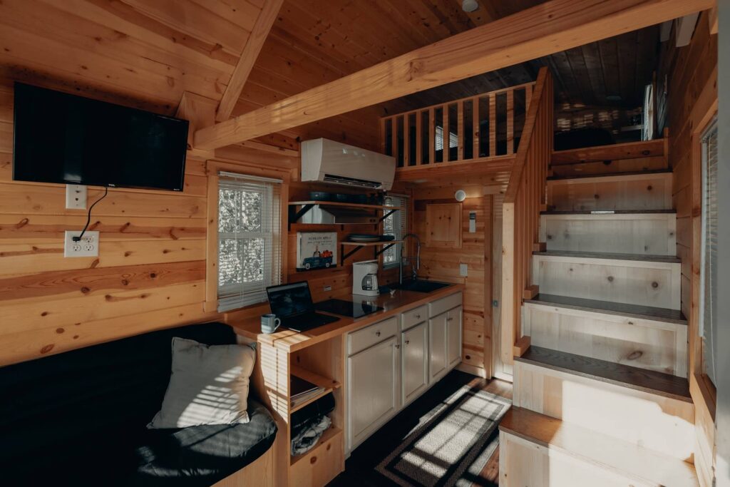 Interior de pequena residência, com cozinha e banheiro no pavimento inferior e dormitório no superior.
