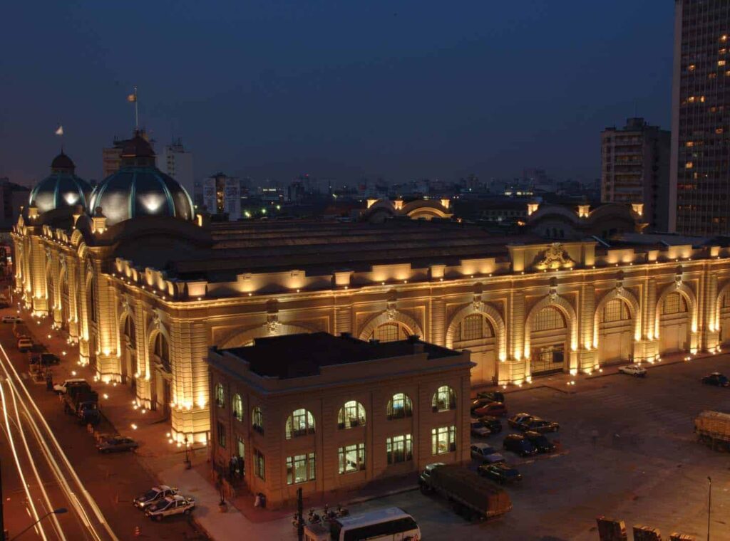 Vista aérea do Mercado Municipal ao fim de tarde, com iluminação artificial destacando a sua arquitetura.