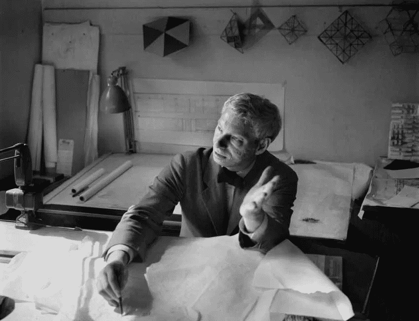 Louis Kahn debruçado em pranchas de desenho arquitetônico.