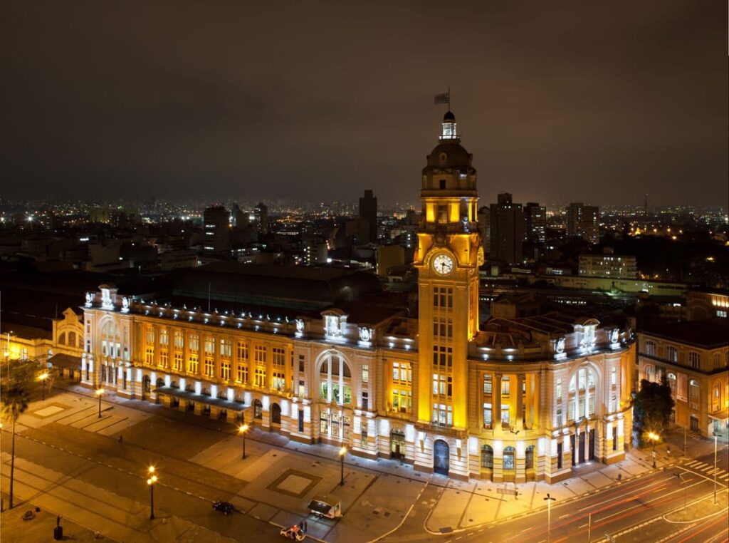 Vista aérea da Sala São Paulo durante a noite, com luzes em toda a sua fachada e torre.
