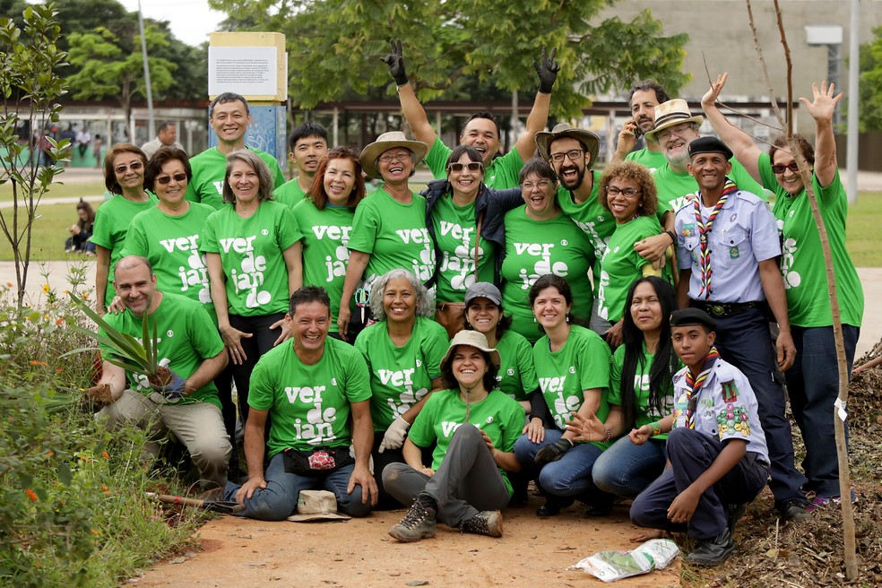 Voluntários do projeto Verdejando no Parque da Juventude posam para a foto ao lado de algumas mudas e vestem camisetas verdes estampadas com a palavra "Verdejando".
