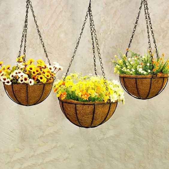 Vasos de fibra de coco, com flores dentro, uma opção mais leve para seu jardim suspenso.
