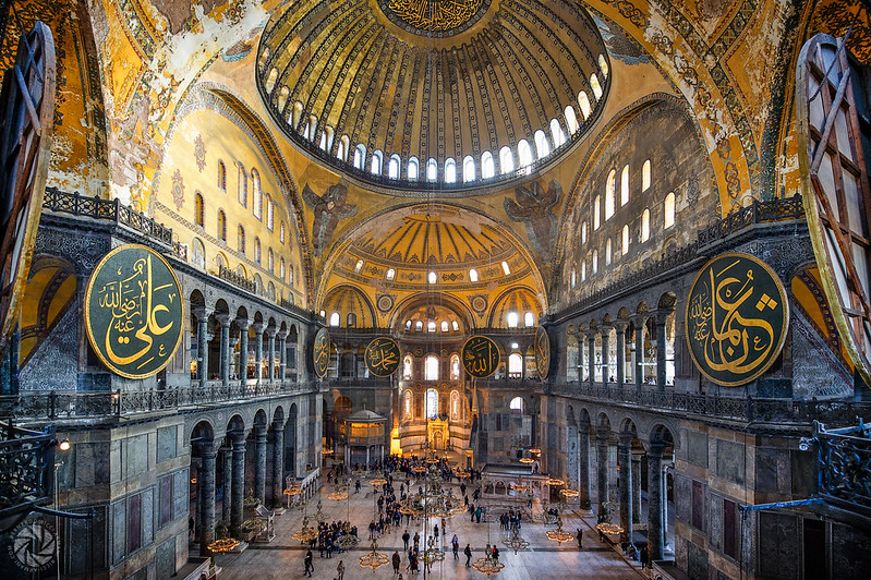 Interior da Basílica com revestimentos dourados na cobertura e diversas janelas favorecendo a entrada de iluminação na parte superior.