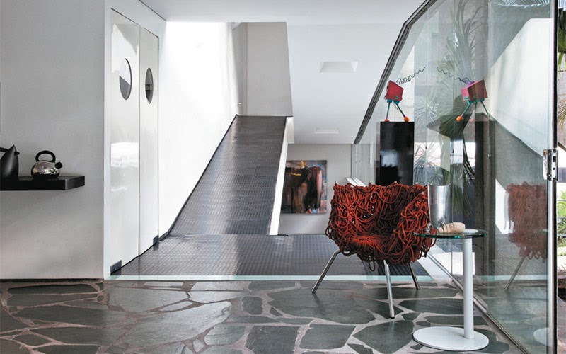 Apartamento com acessibilidade: rampa adaptada para cadeirantes, em uma sala em tons de branco e cinza. 