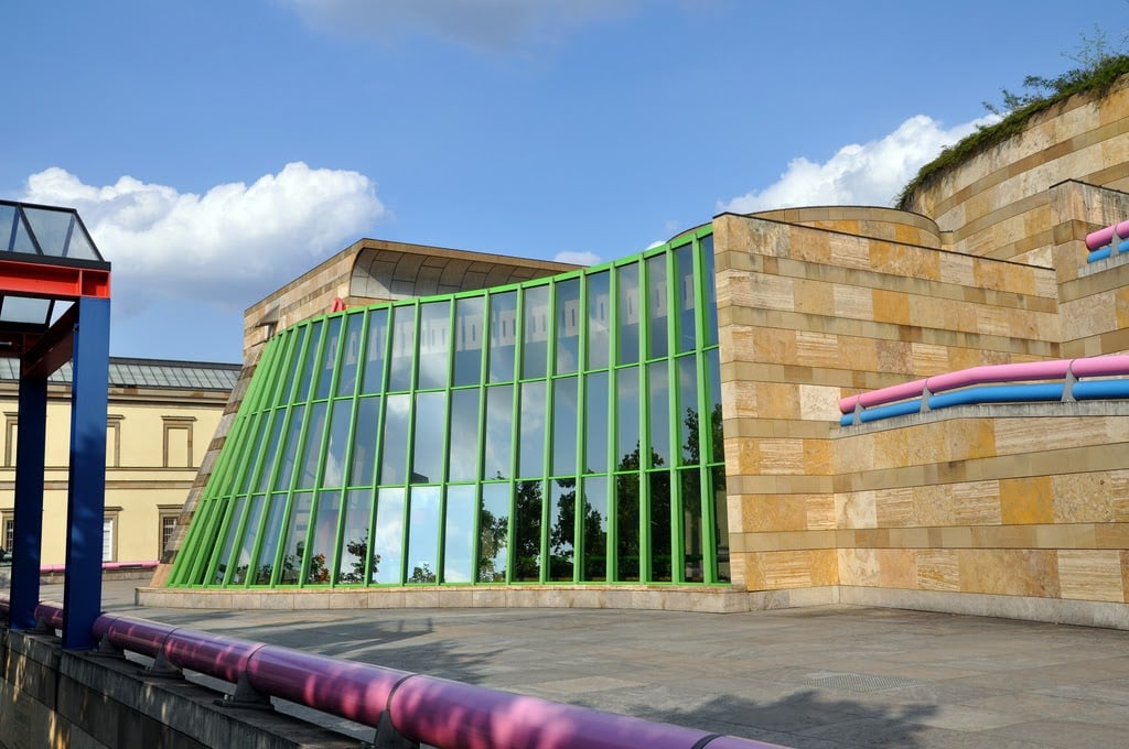 Fachada do museu Neue Staatsgalerie, com paredes curvas e metais coloridos.