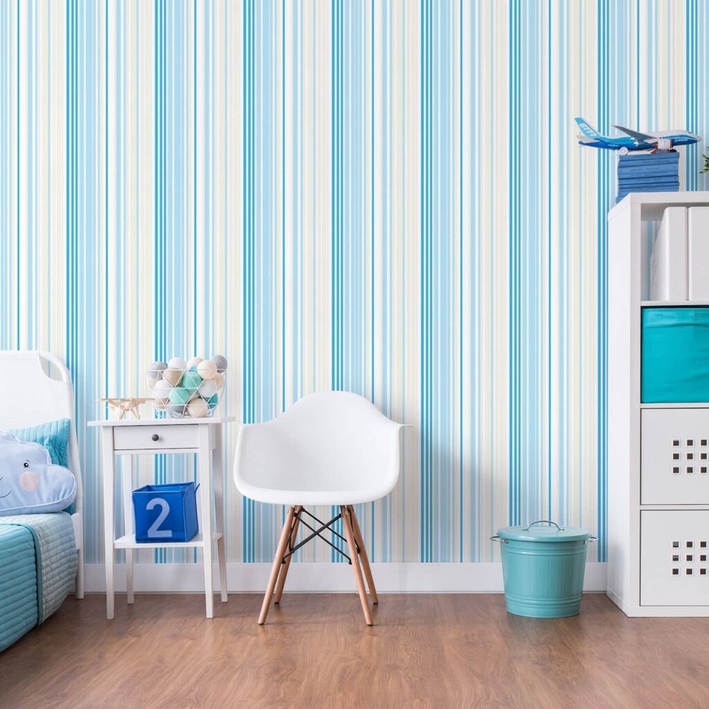 Quarto infantil com decoração monocromática feita em azul com papel de parede. A padronagem traz linhas me diferentes tons, na vertical.
